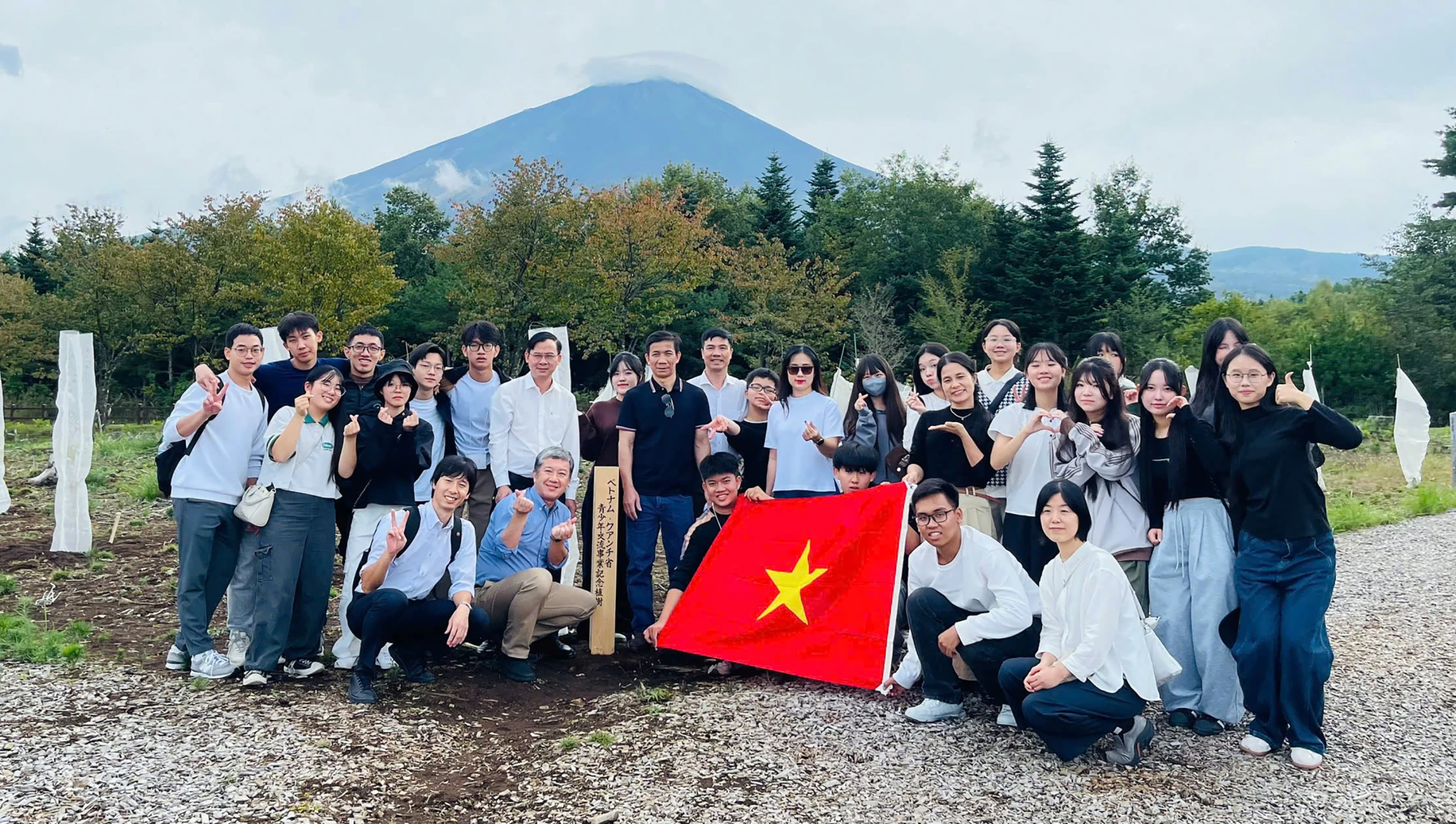 Em Trần Minh Đăng (người phía bên trái cờ Tổ quốc) và các thành viên đoàn công tác ngành Giáo dục Quảng Trị giao lưu với Trường THPT Fuefuki, tỉnh Yamanashi (Nhật Bản) - Ảnh: N.M