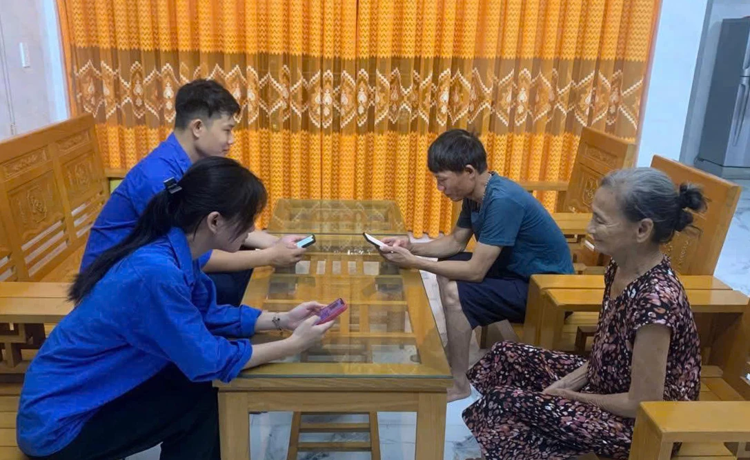 Đoàn viên, thanh niên hướng dẫn người dân cài đặt và sử dụng ứng dụng VNeID -Ảnh: M.H