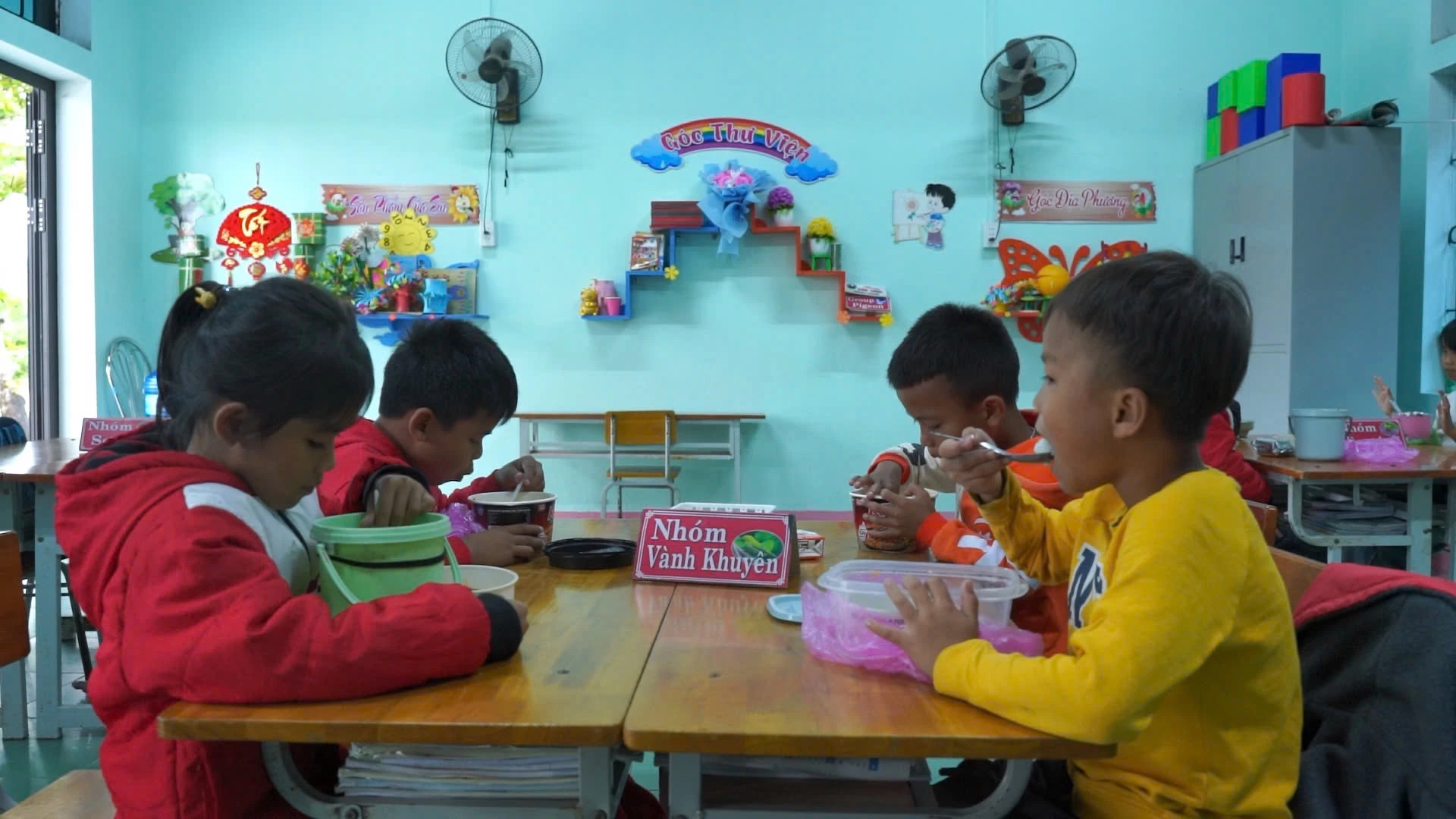 Bữa cơm trưa tự túc của các em học sinh Trường Nội trú Tiểu học và Trung học cơ sở Kim Ngân tại lớp học -Ảnh: Phan Khiêm

