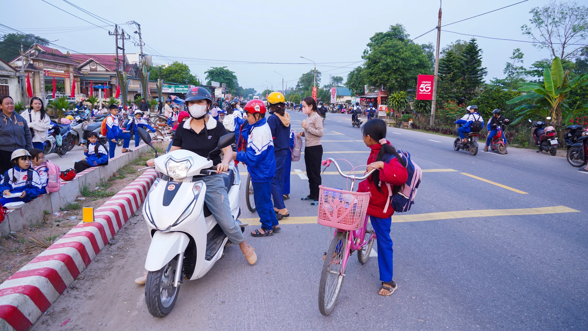 Nhiều phụ huynh dừng ngay lòng đường tuyến tránh phía Bắc Đông Hà đoạn qua xã Hiếu Giang để đưa đón học sinh đến trường - Ảnh: L.T