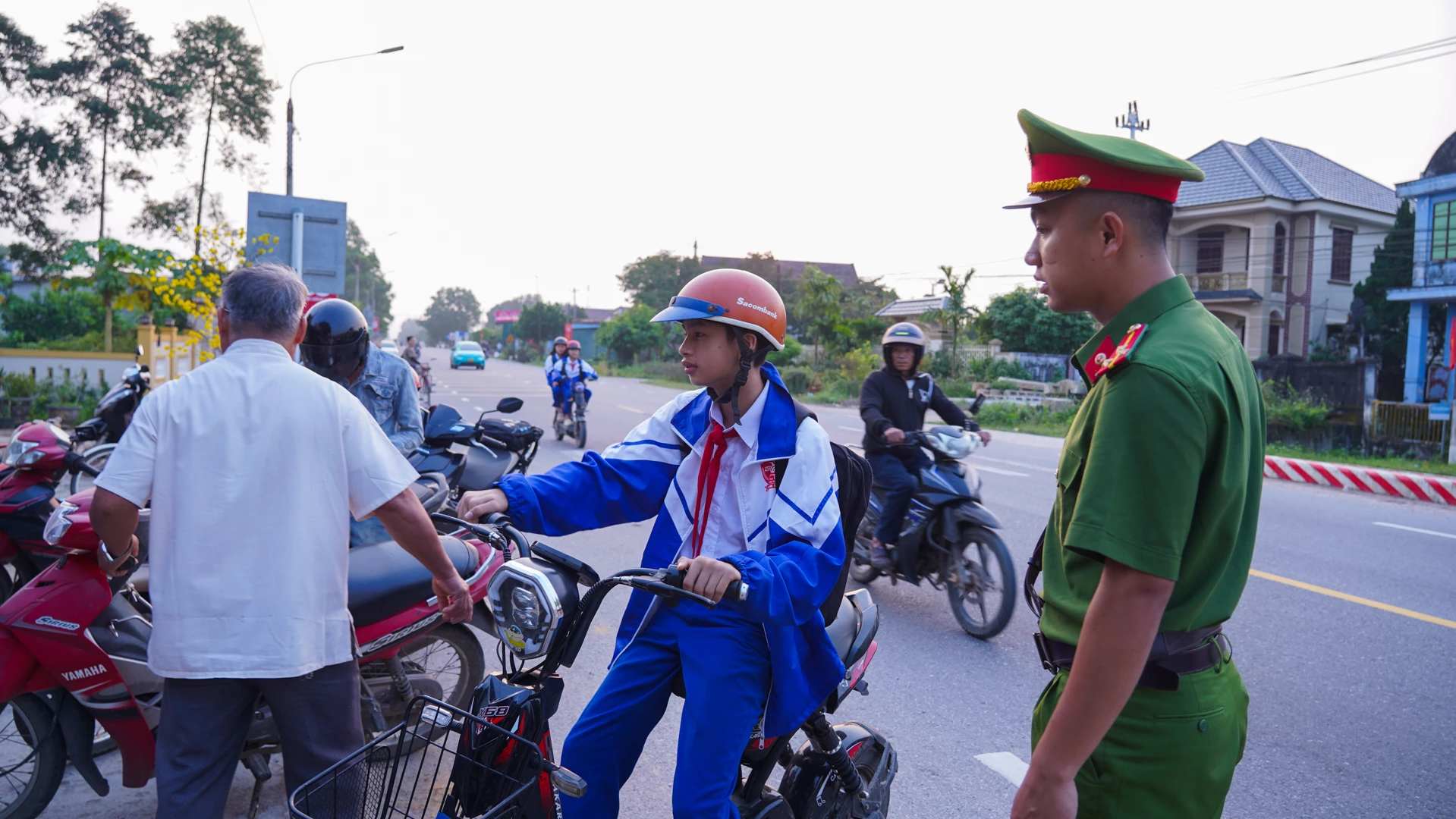 Lực lượng Công an xã Hiếu Giang nhắc nhở việc đậu đỗ phương tiện trước cổng trường Tiểu học và THCS Cam Thuỷ để đảm bảo ATGT nhưng rồi đâu vào lại đó khi lực lượng chức năng rời đi - Ảnh: L.T
