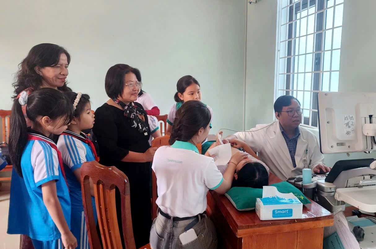 Lãnh đạo Hội Bảo trợ BNN tỉnh thăm, động viên các em học sinh đang được khám sàng lọc- Ảnh: TL.