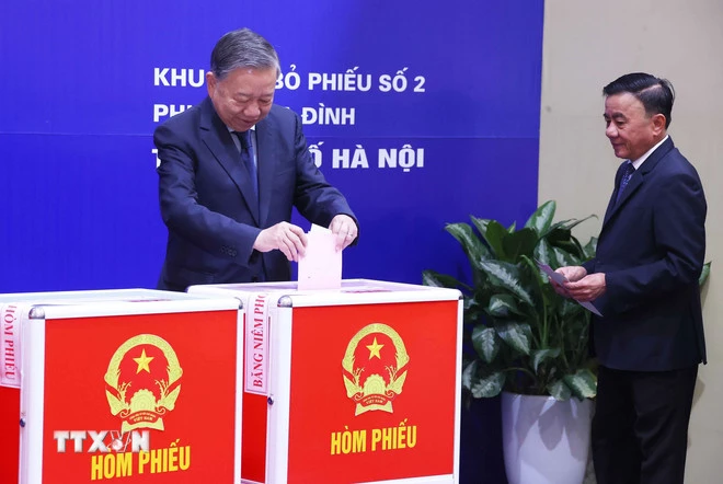 Tổng Bí thư Tô Lâm, đồng chí Trần Cẩm Tú, Ủy viên Bộ Chính trị, Thường trực Ban Bí thư và các cử tri bỏ phiếu bầu cử tại Khu vực bỏ phiếu số 02 phường Ba Đình, thành phố Hà Nội. (Ảnh: Văn Điệp/TTXVN)