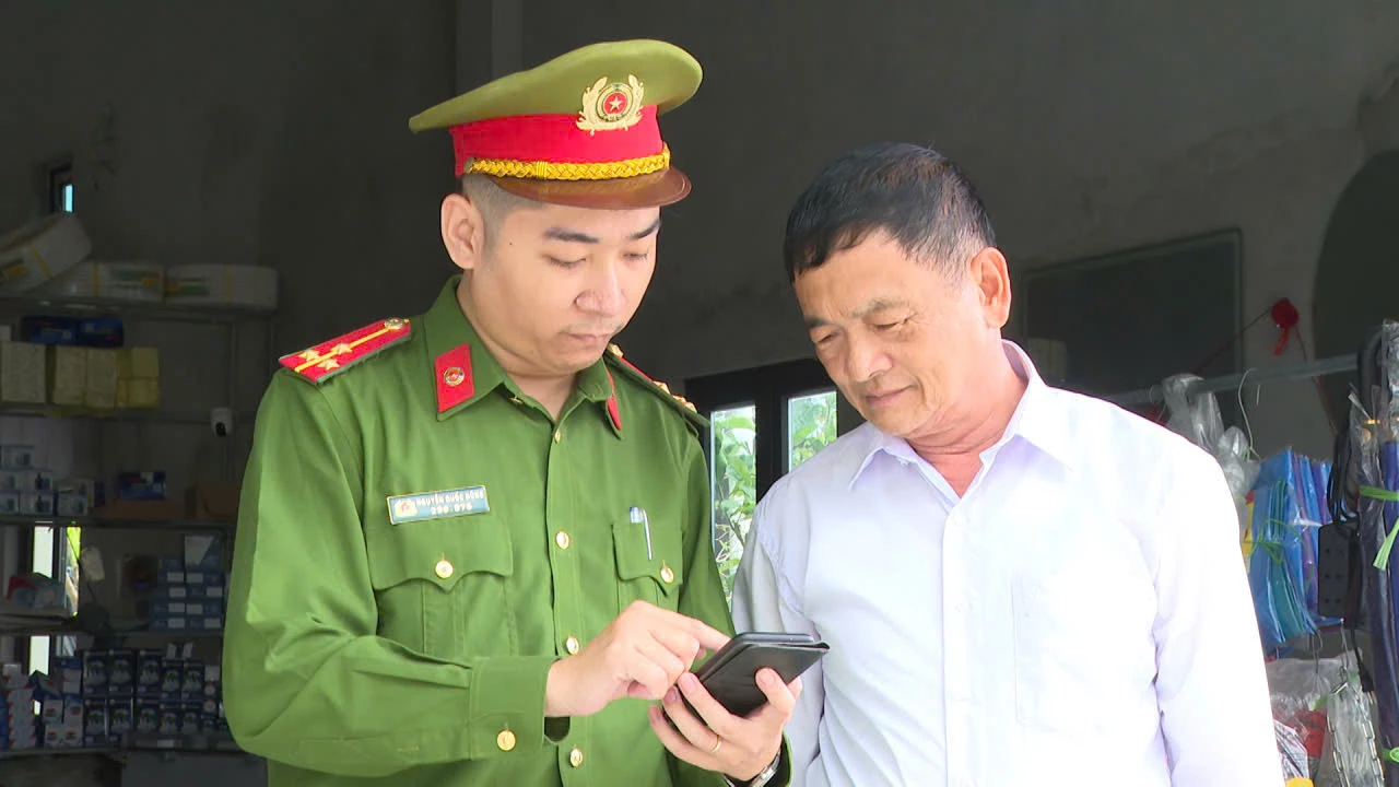 Công an xã hướng dẫn người dân cách đăng ký thay đổi nơi bỏ phiếu trên ứng dụng VneID - Ảnh: M.L