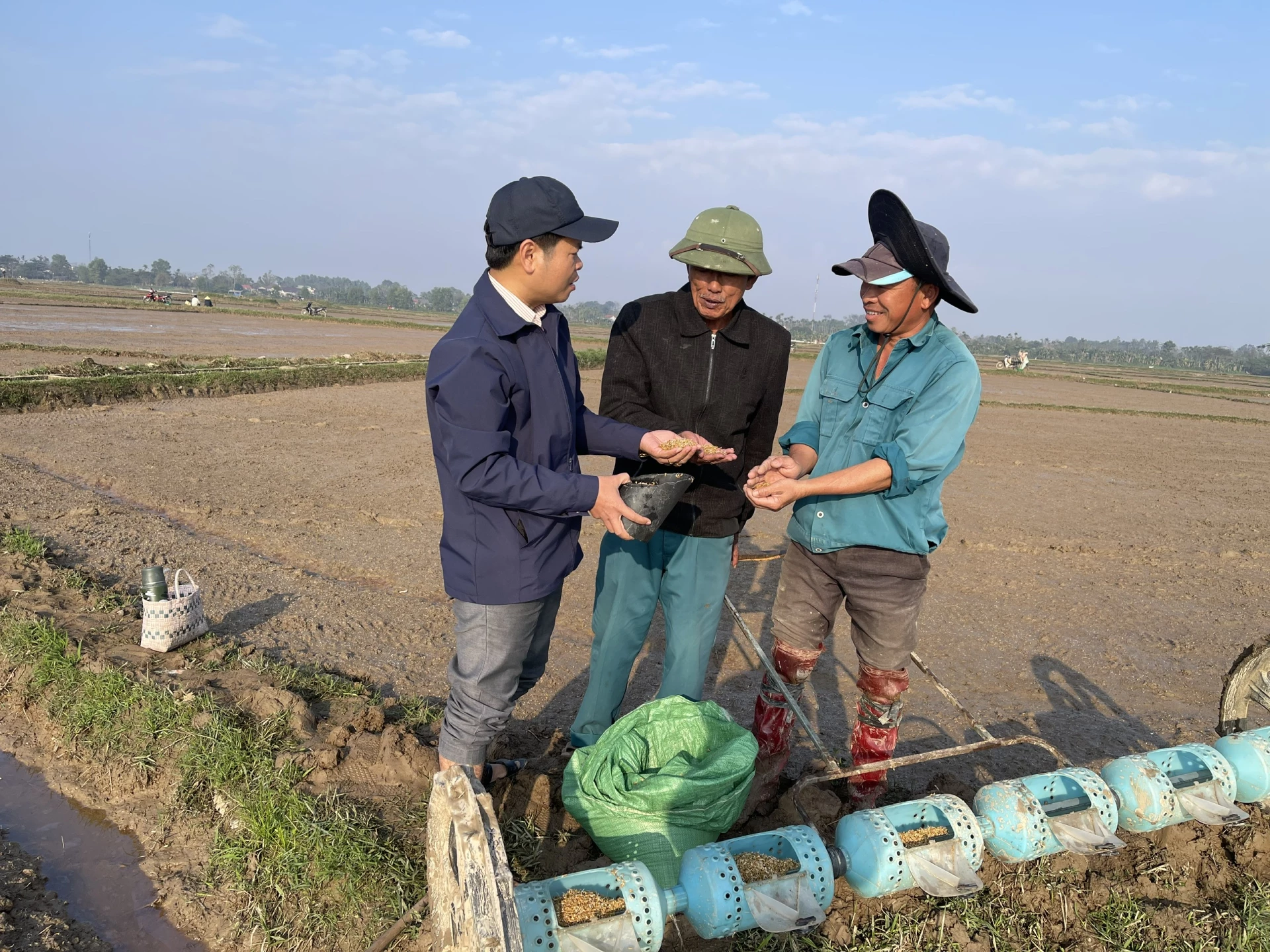 Anh Phan Việt Toàn (ngoài cùng bên trái) hướng dẫn nông dân gieo sạ lúa tiết kiệm, hiệu quả - Ảnh: Đ.V