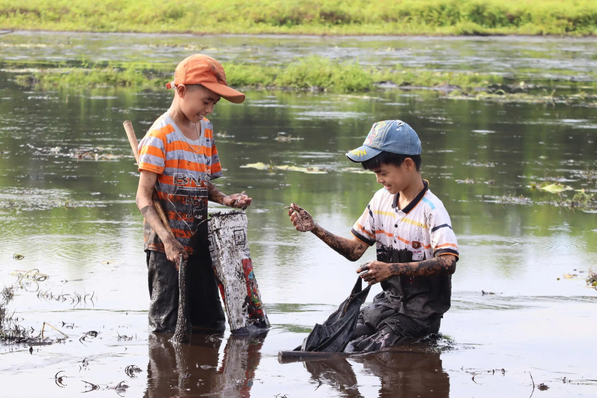 Trẻ con háo hức mót cá nhỏ sót lại trong lòng ao - Ảnh: D.T