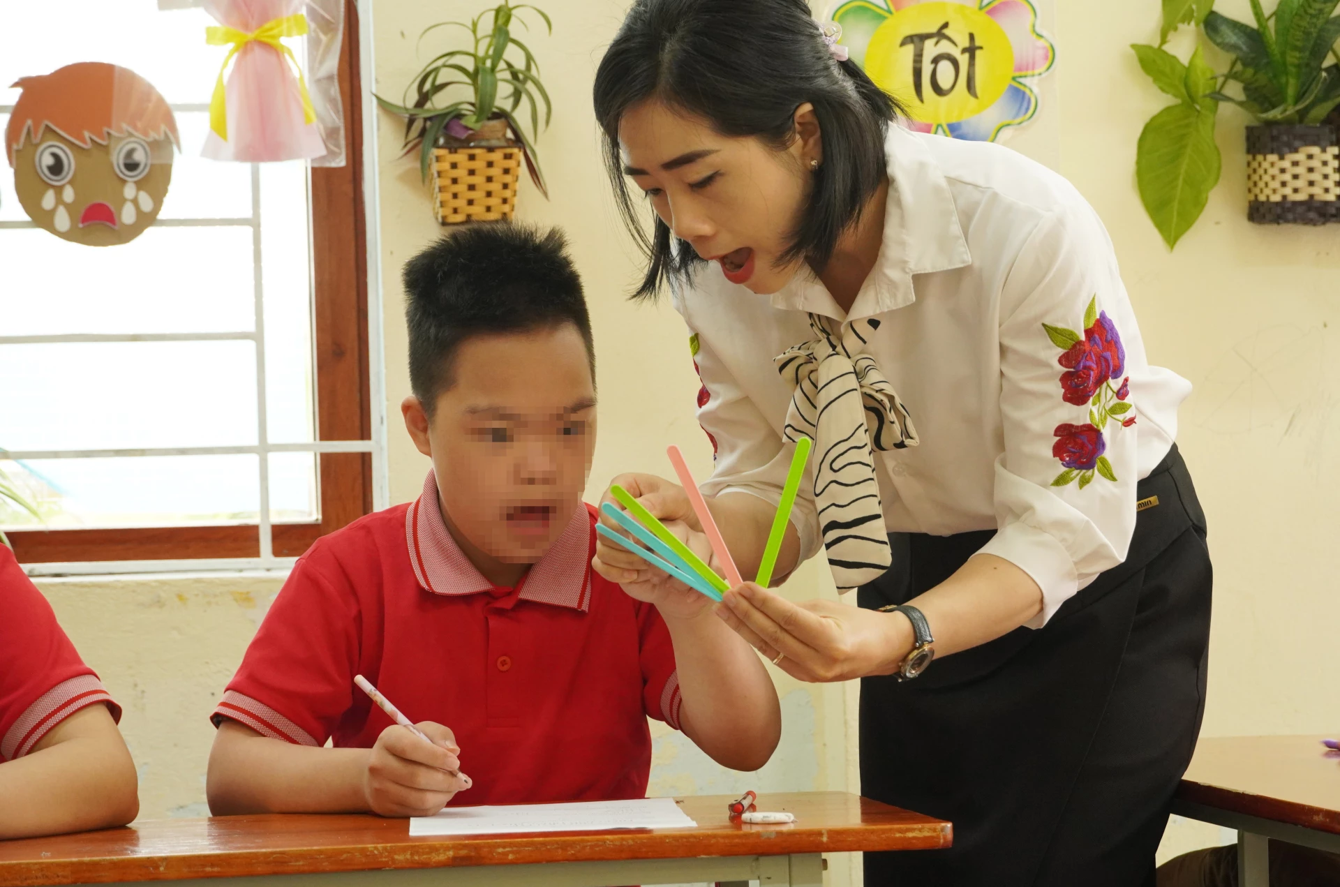 Việc truyền dạy kiến thức cho trẻ khuyết tật cần sự kiên nhẫn, tình yêu thương của các giáo viên- Ảnh: H.L