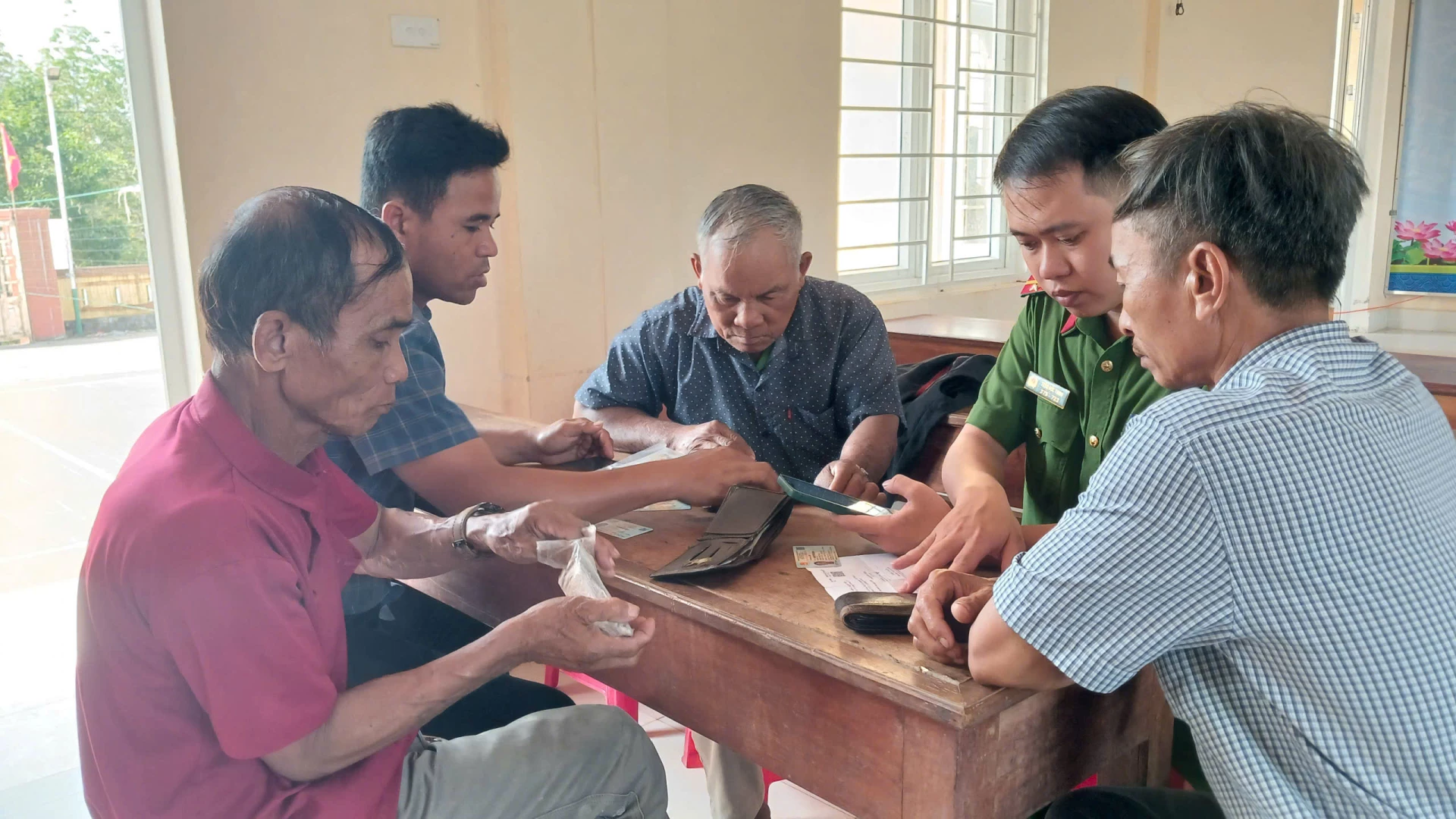 Cán bộ cơ sở hướng dẫn người dân vùng núi thực hiện các thủ tục hành chính trên nền tảng số - Ảnh: N.B