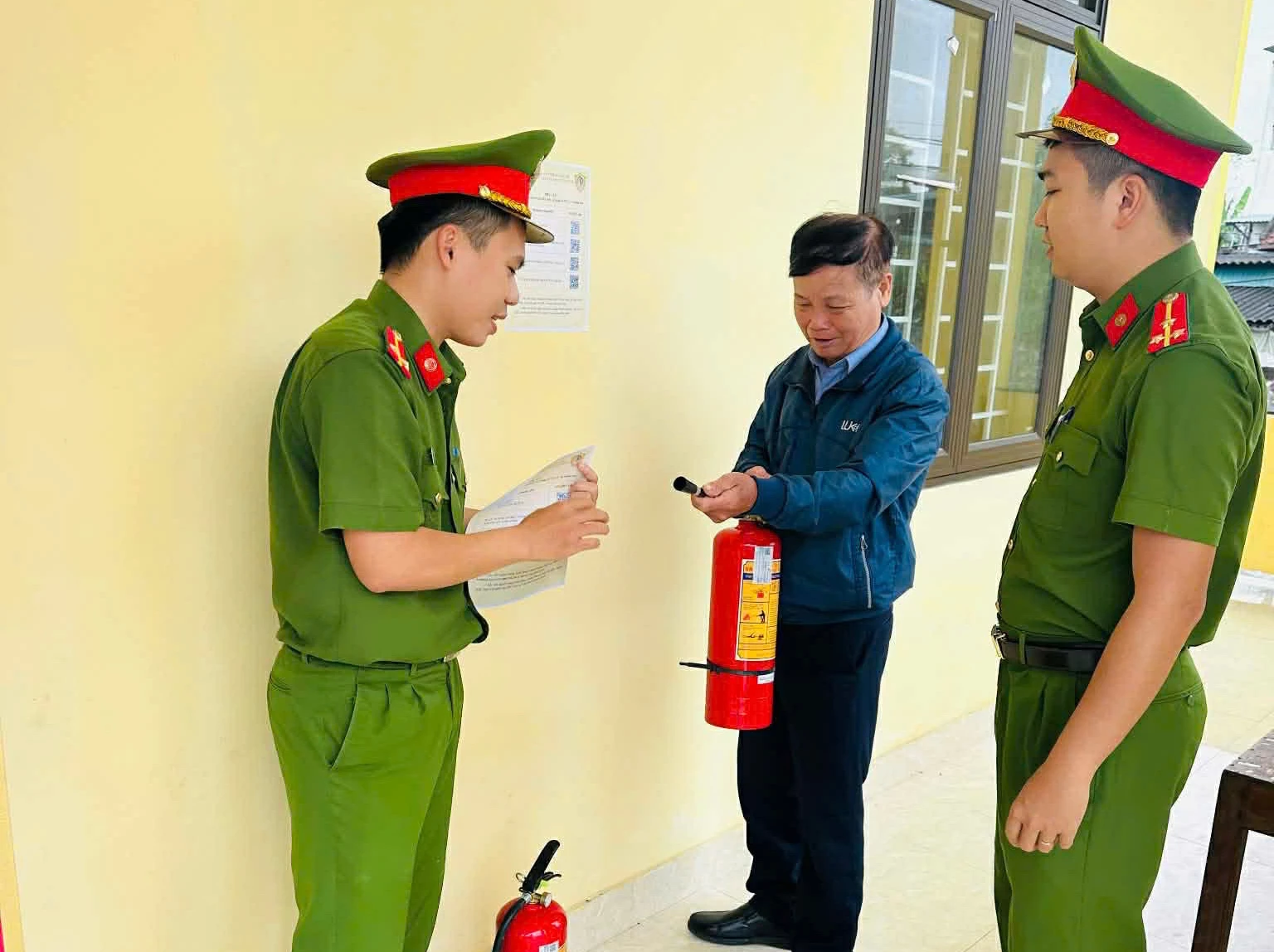 Công an xã Nam Trạch hướng dẫn việc sử dụng bình chữa cháy - Ảnh: CANT