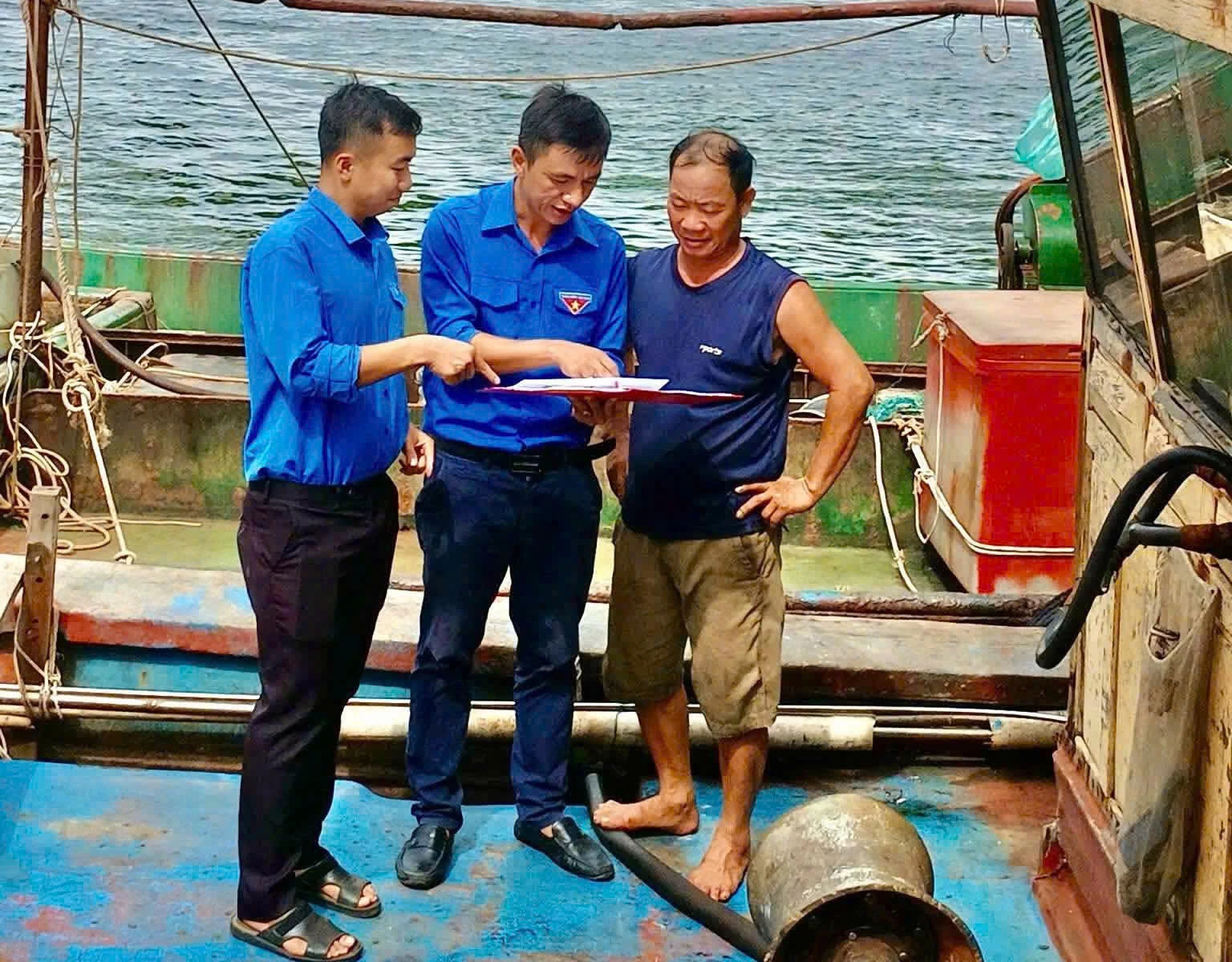 Đoàn viên Đoàn UBND tỉnh tuyên truyền chống khai thác IUU cho ngư dân - Ảnh: Đ.K