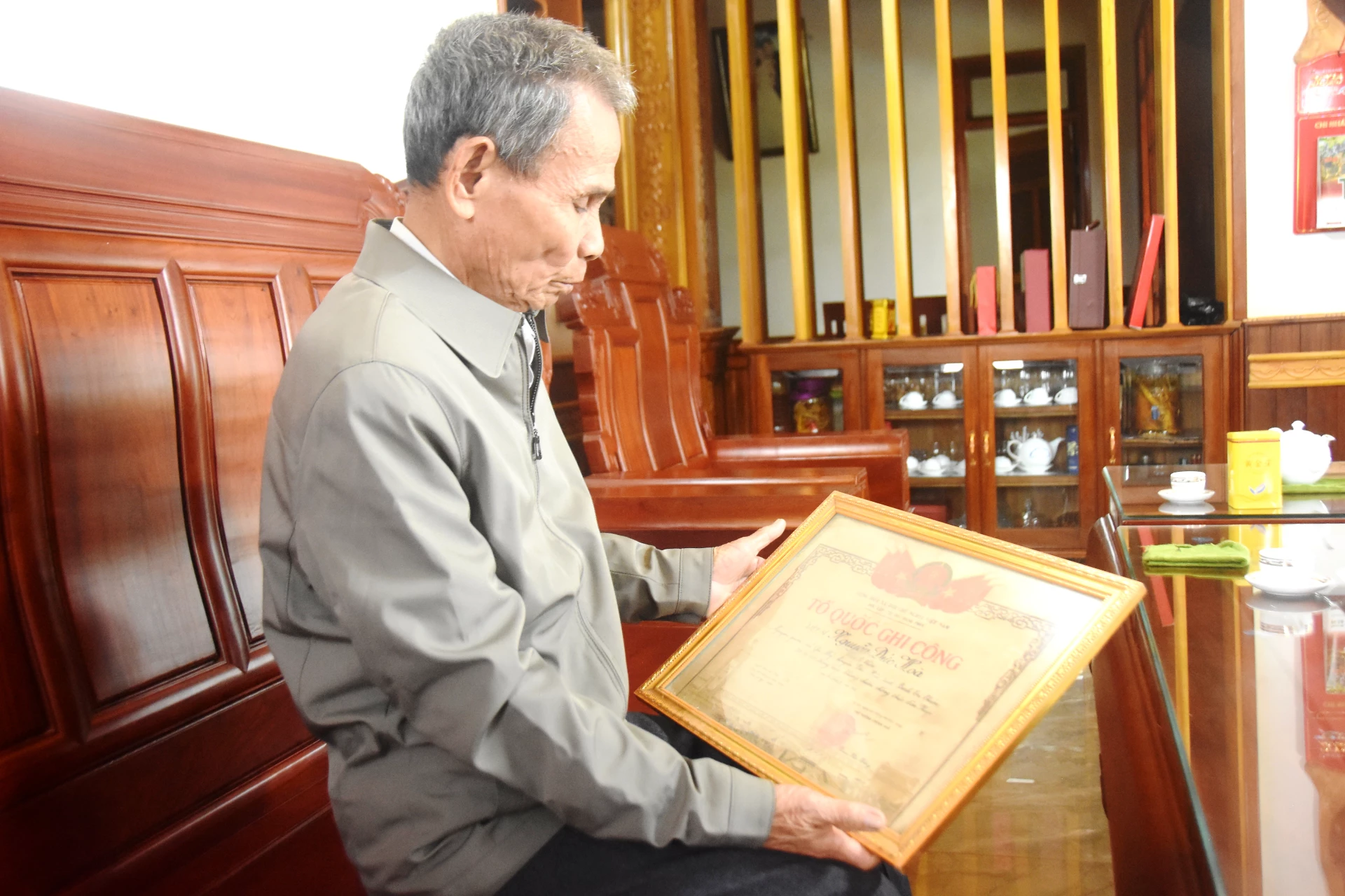 Ông Nguyễn Đức Phương bên tấm bằng Tổ quốc ghi công của cha, liệt sĩ Nguyễn Đức Hòa - Ảnh: Đ.V