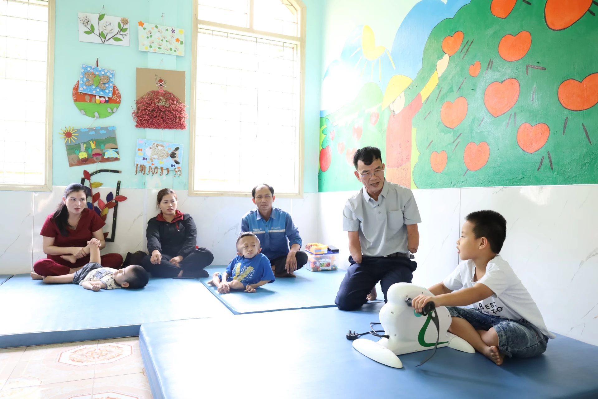 Ông Nguyễn Thanh Hảo hướng dẫn tập luyện vận động cho trẻ khuyết tật tại trung tâm - Ảnh: Q.N