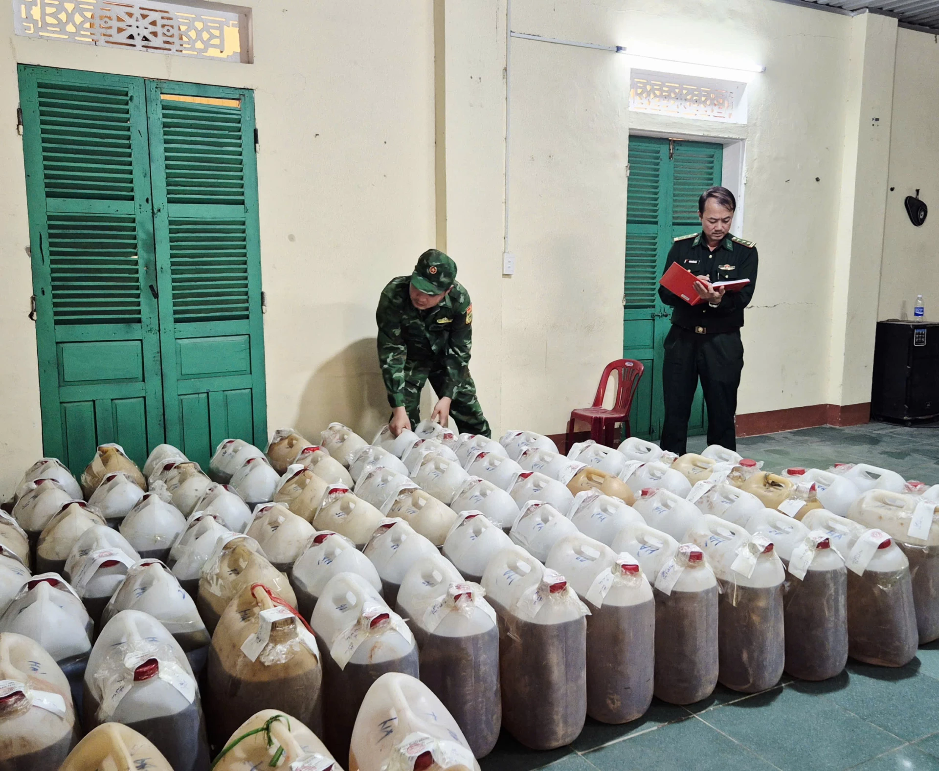 Lực lượng Biên phòng kiểm đếm tang vật là các can xăng dầu lậu được tập kết trái phép trên địa bàn xã Lao Bảo - Ảnh: K.S