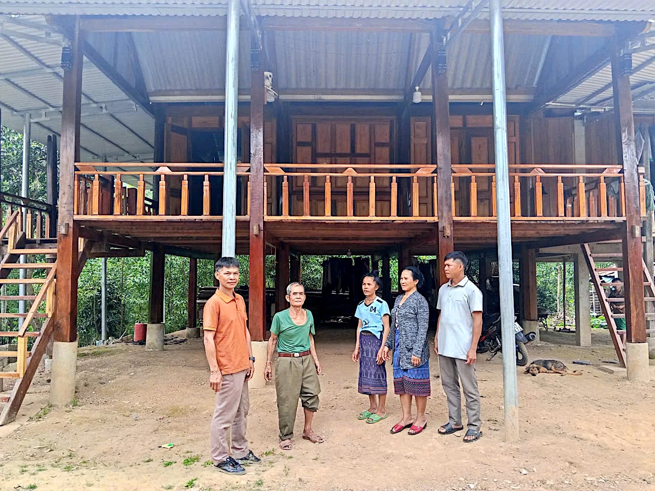 Anh Hồ Bông (ngoài cùng bên trái) trò chuyện với bà con dân bản trước ngôi nhà vừa được hoàn thiện - Ảnh: Q.N