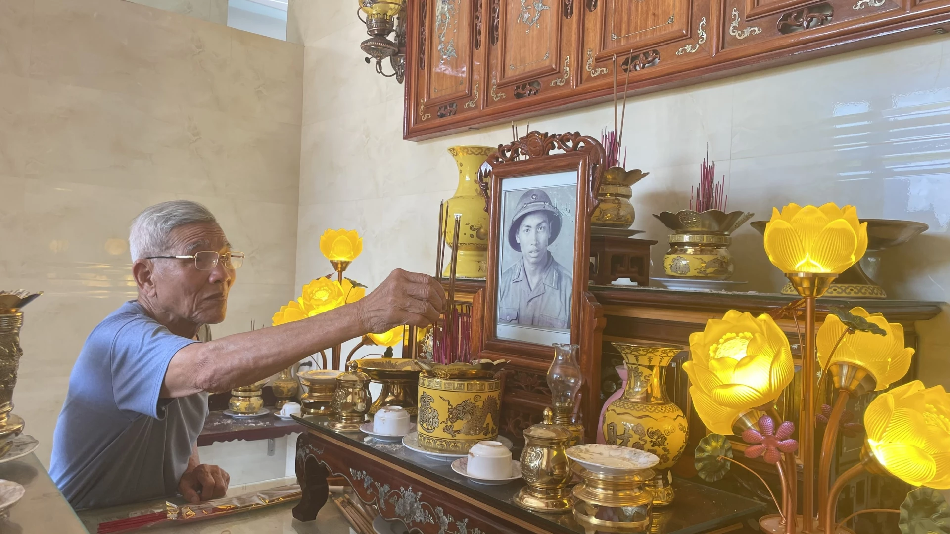 Ông Hoàng Quang Lắc thắp hương cho người đồng đội đã khuất, liệt sĩ Nguyễn Văn Đoi - Ảnh: L.T