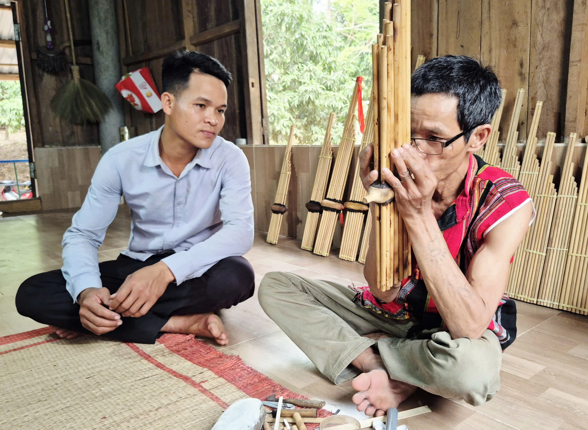 Nghệ nhân Pả Hơi (bên phải) truyền dạy cách sử dụng khèn bè cho thế hệ trẻ - Ảnh: K.S