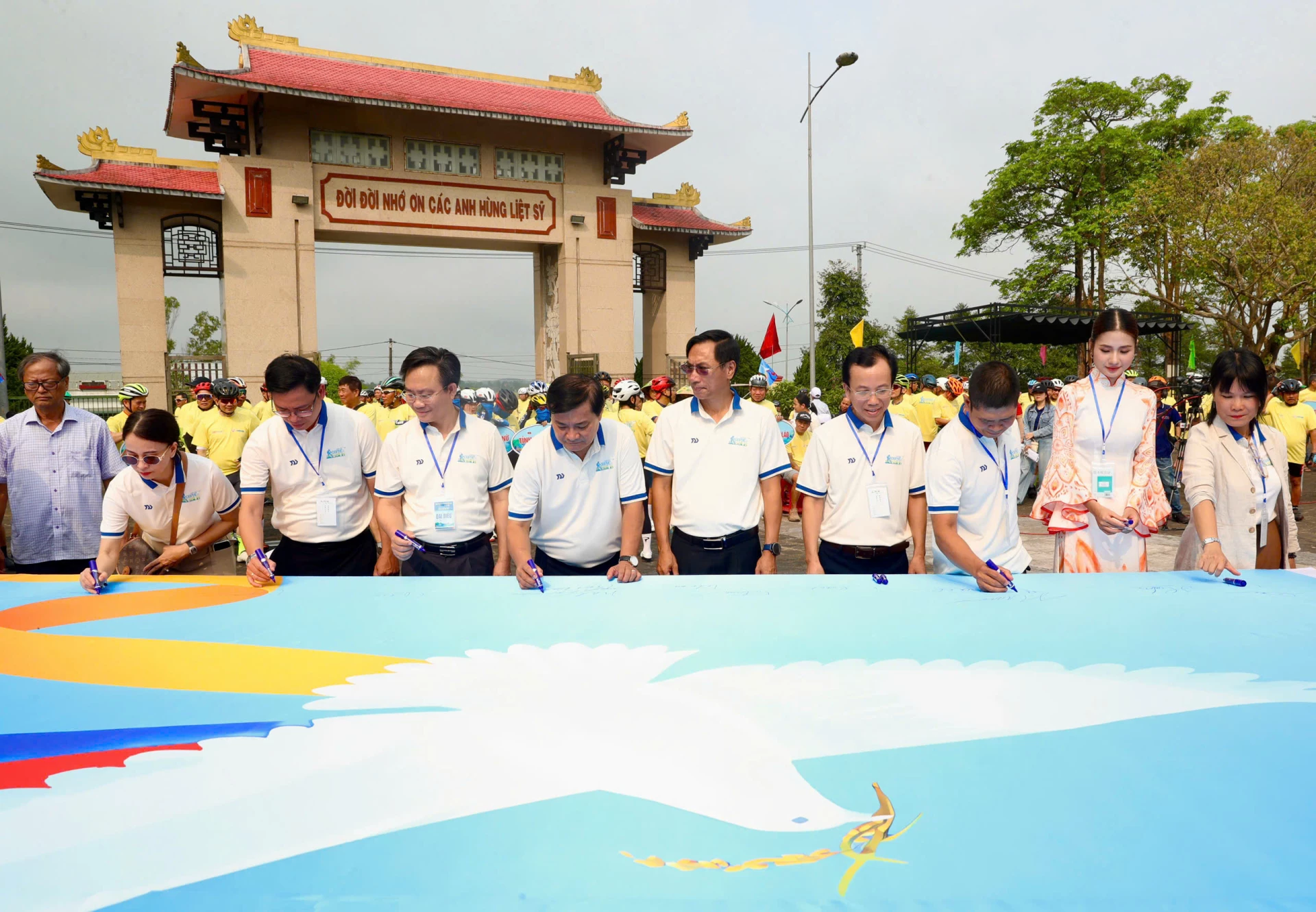 Các đại biểu ký tên vào lá cờ Lễ hội vì hòa bình - Ảnh: BTC