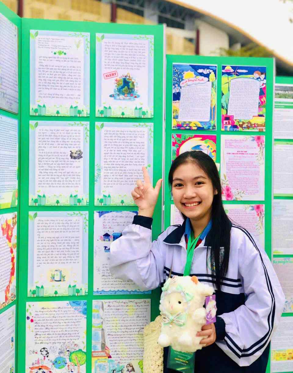 Khánh Minh chụp ảnh lưu niệm bên bức thư của mình-Ảnh: NVCC