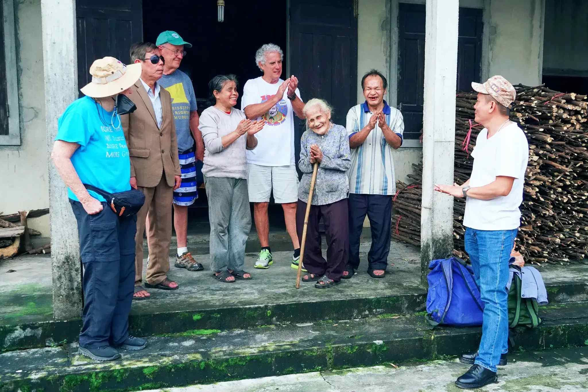 Nhóm UP chia sẻ niềm vui với mẹ con bà Thứ sau khi giúp gia đình lợp mái nhà - Ảnh: Q.H