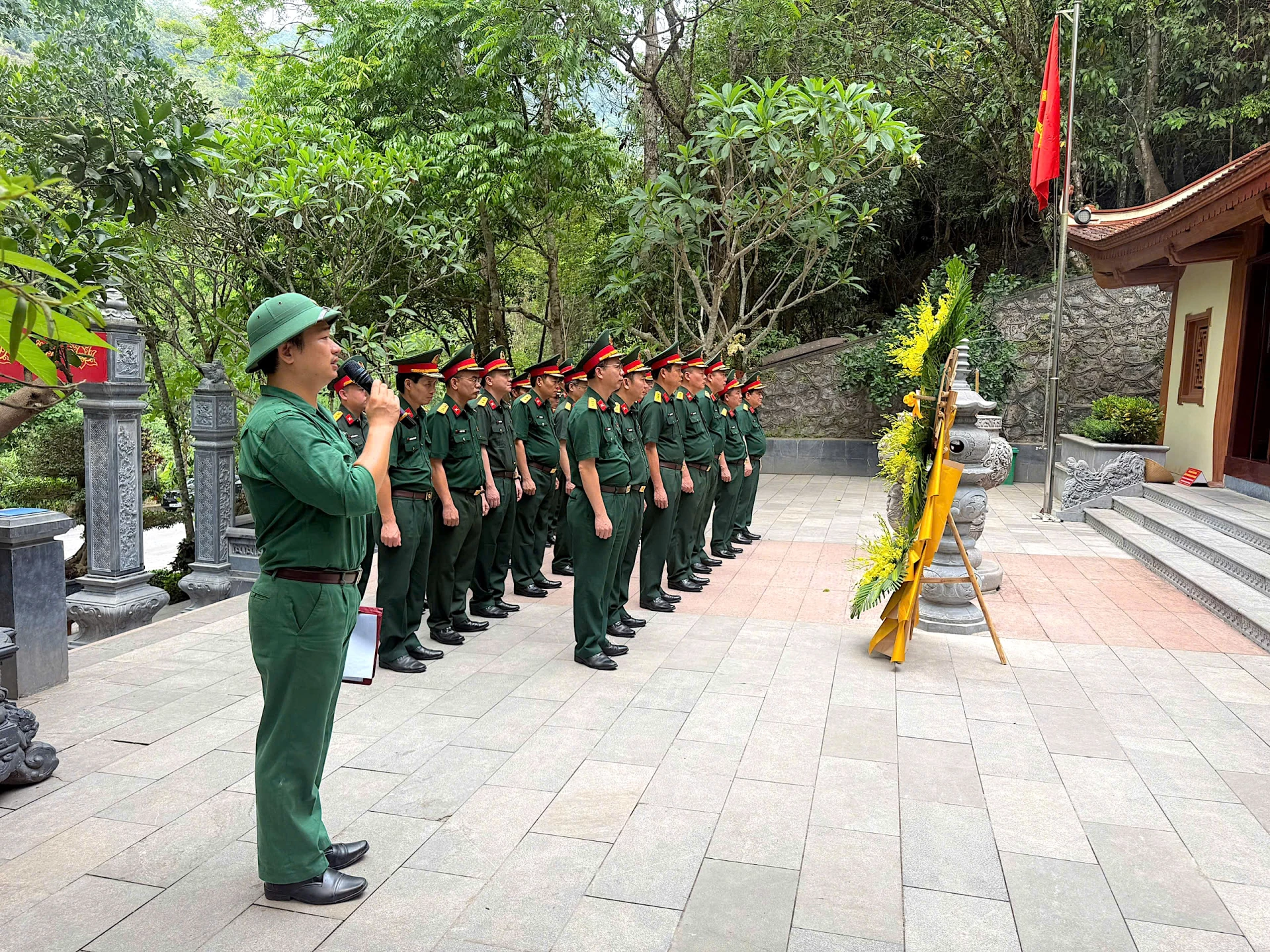 Anh Nguyễn Ngọc Hoàng (bên trái ngoài cùng) hướng dẫn các đoàn đến đặt hoa, làm lễ tại Đền tưởng niệm các Anh hùng liệt sĩ đường 20 Quyết Thắng - Ảnh: Q.N
