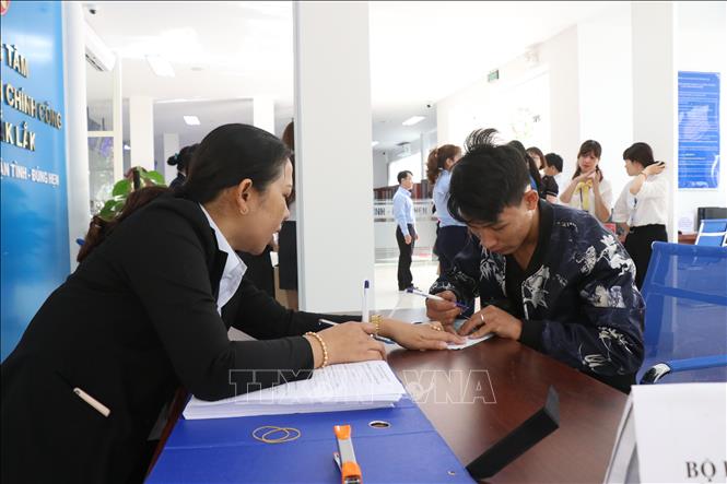 Nhân viên Trung tâm Phục vụ Hành chính công tỉnh Đắk Lắk hướng dẫn người dân làm thủ tục hành chính. Ảnh: Tuấn Anh/TTXVN