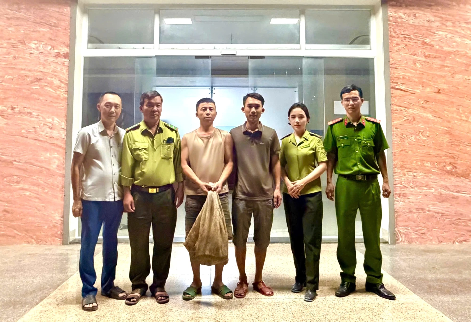 Anh Lê Thanh Tùng (thứ 3, bên phải sang) cùng bạn giao nộp 2 cá thể Tê tê cho chính quyền địa phương và cơ quan chức năng - Ảnh: L.T