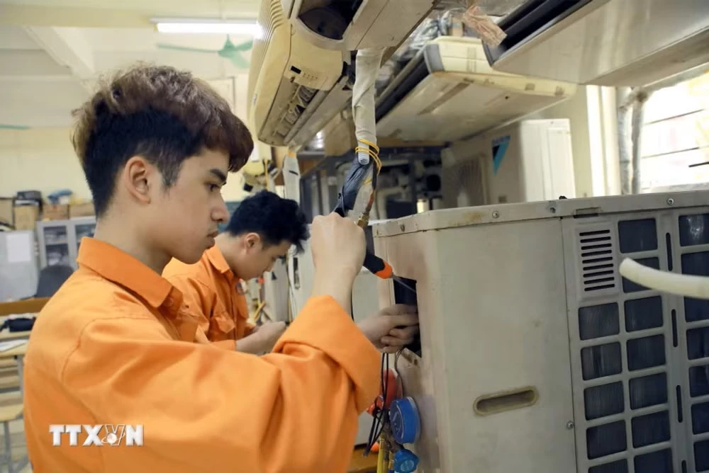 Sinh viên trường Cao đẳng Kỹ thuật-Công nghệ Vĩnh Phúc thực hành sửa chữa thiết bị tại phòng thực hành máy lạnh công nghiệp. (Ảnh: Hoàng Hùng/TTXVN)