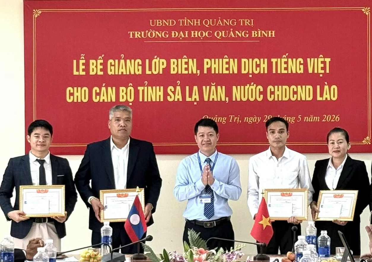 Hiệu trưởng Trường đại học Quảng Bình tặng giấy khen cho các học viên đạt thành tích cao - Ảnh: N.L
