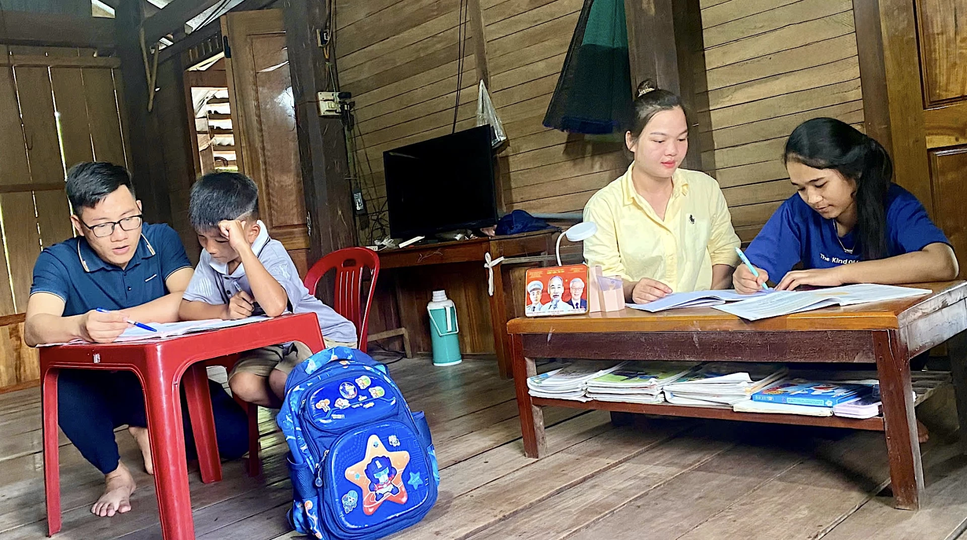 Thầy giáo Trần Mạnh Hùng kiểm tra góc học tập của học sinh ở bản Y Leng - Ảnh: Q.N