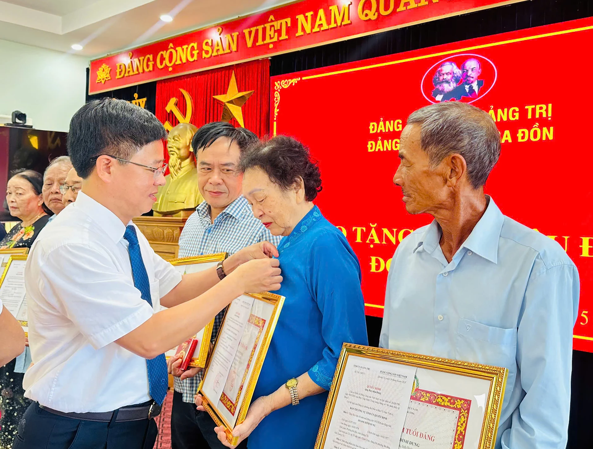 Đại diện lãnh đạo Đảng ủy phường Ba Đồn trao Huy hiệu Đảng cho các đảng viên - Ảnh: HL