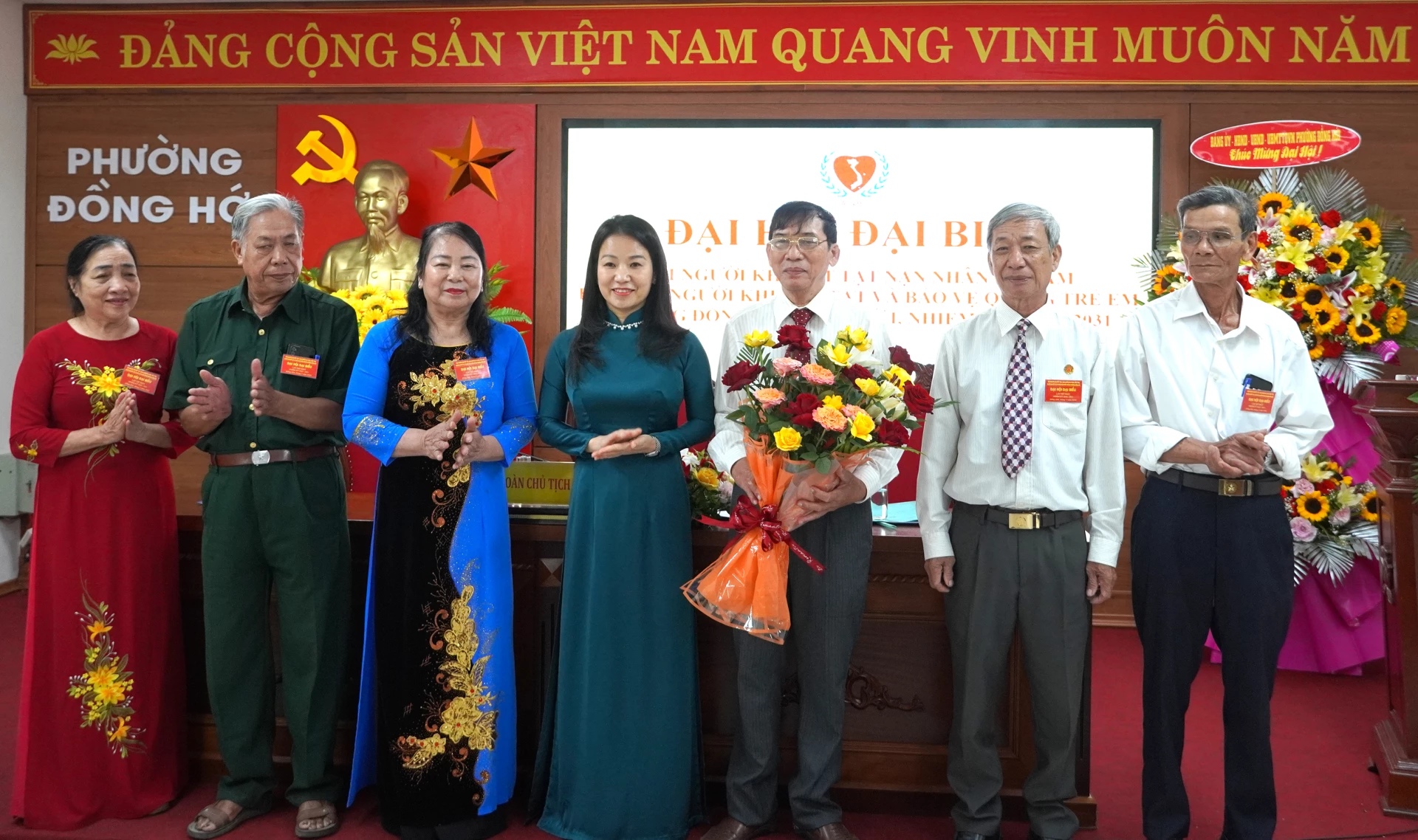 Đại diện lãnh đạo phường Đồng Hới tặng hoa chúc mừng Ban Chấp hành Hội NKT, NNDC, bảo trợ NKT và bảo vệ quyền trẻ em phường - Ảnh: H.Tr.