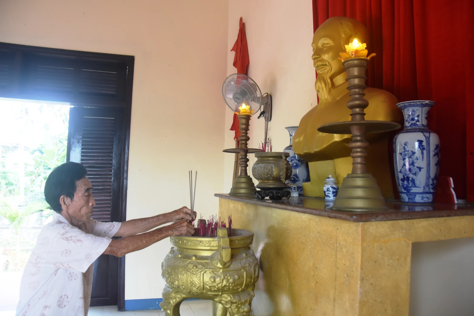 Ông Phan Hữu Thiện thắp nén nhang lên bàn thờ Bác Hồ - Ảnh: Đ.V