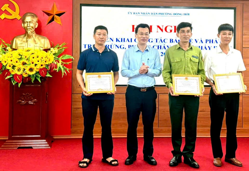 Đại diện lãnh đạo phường Đồng Hới trao giấy khen tặng 3 cá nhân - Ảnh: H.Tr.