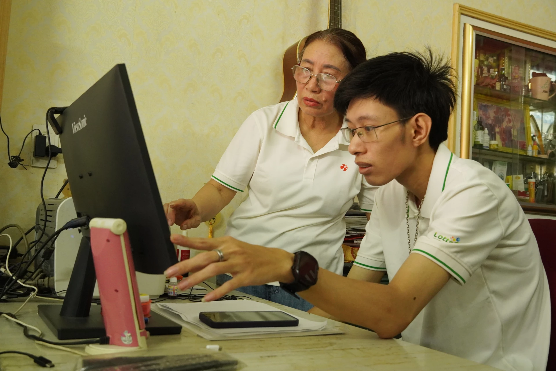 Các thành viên nhiều thế hệ cùng nhau hỗ trợ sử dụng công nghệ - Ảnh: H.L