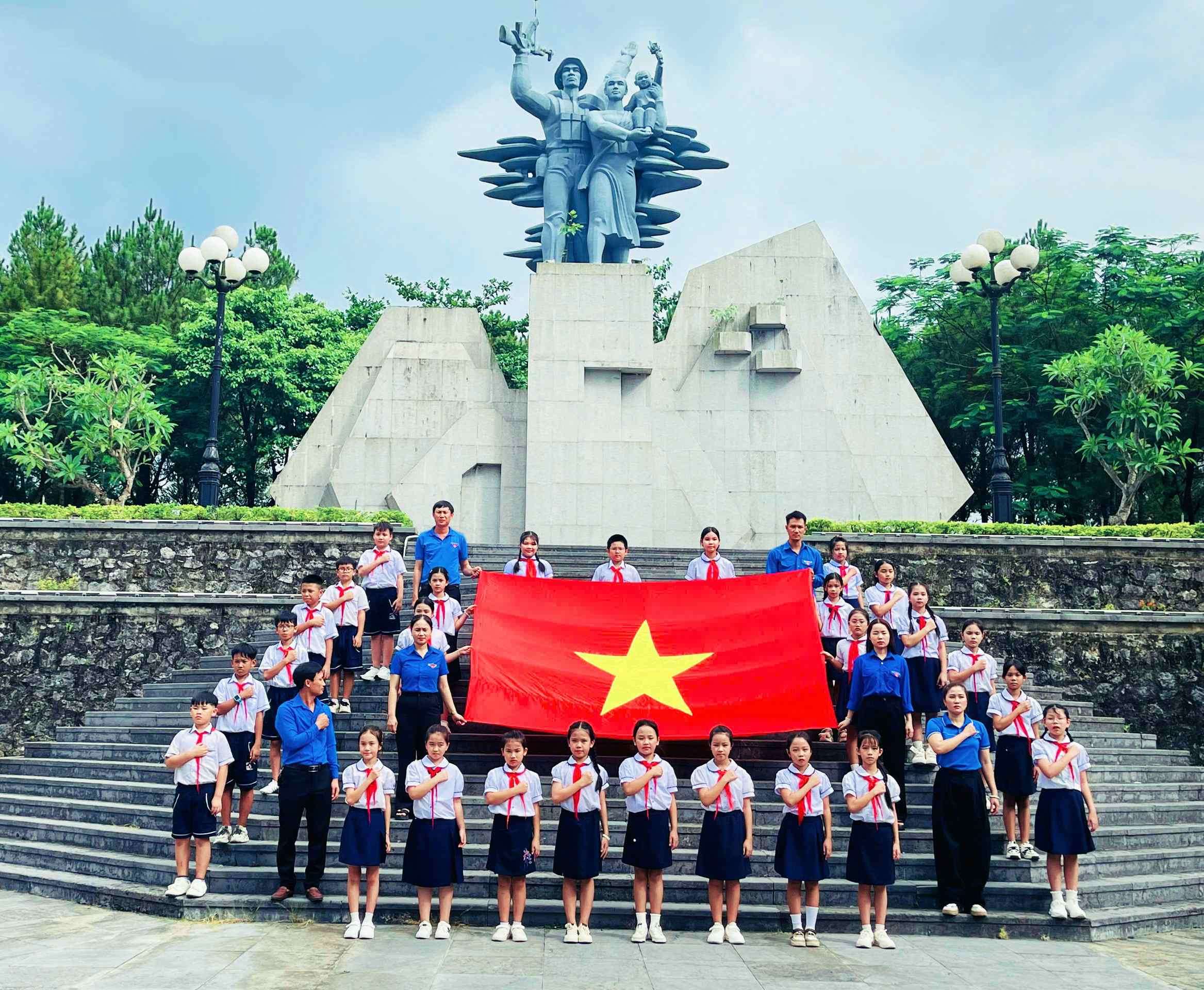 Giáo viên, học sinh Trường tiểu học Hàm Nghi tổ chức hoạt động hát quốc ca tại địa chỉ đỏ-Ảnh: Q.H