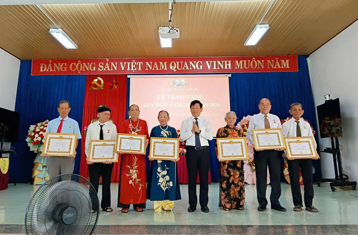 Đồng chí Lê Vĩnh Thế, Chánh Văn phòng Tỉnh ủy trao huy hiệu Đảng cho các đảng viên thuộc Đảng bộ xã Tân Mỹ - Ảnh: T.Đ