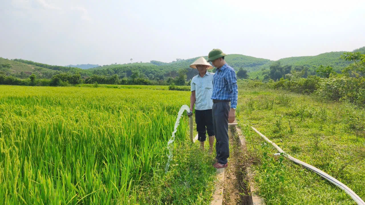 Cán bộ xã Tuyên Lâm hỗ trợ người dân chống hạn cho ruộng lúa - Ảnh: Q.V