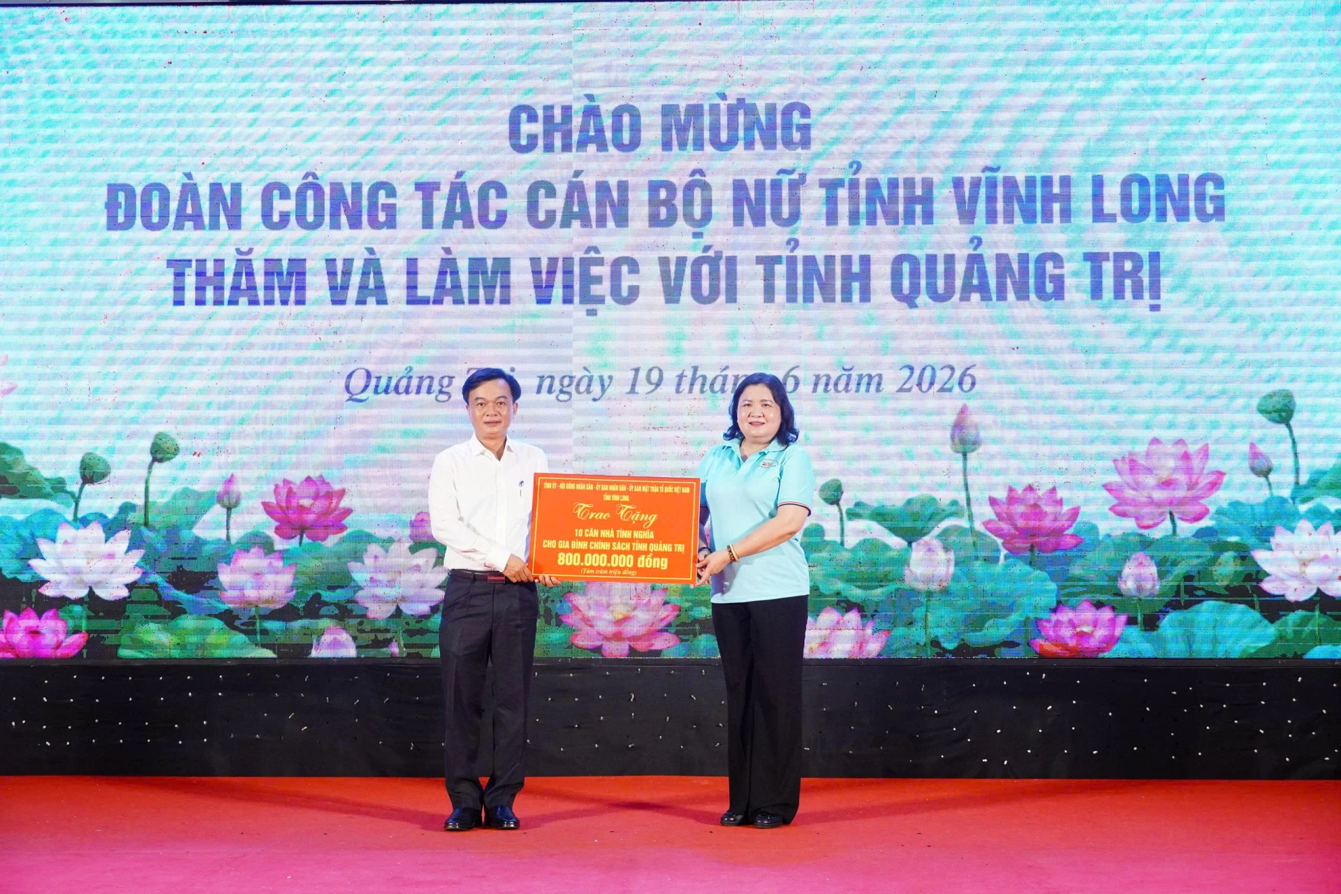 Đồng chí Hồ Thị Hoàng Yến, Ủy viên Ban Chấp hành Trung ương Đảng, Phó Bí thư Thường trực Tỉnh ủy Vĩnh Long trao biển tượng trưng 800 triệu đồng hỗ trợ xây dựng nhà tình nghĩa cho tỉnh Quảng Trị - Ảnh: NL