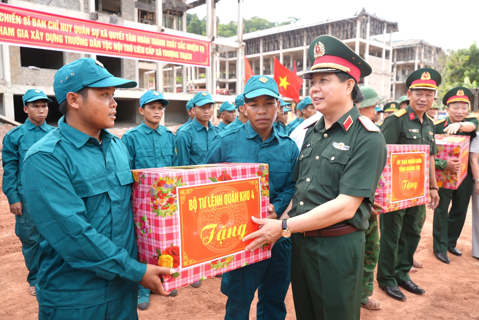 Thiếu tướng Lê Văn Trung, Phó Chính ủy Quân khu 4 tặng quà cho các lực lượng tham gia xây dựng trường học - Ảnh: T.Đ
