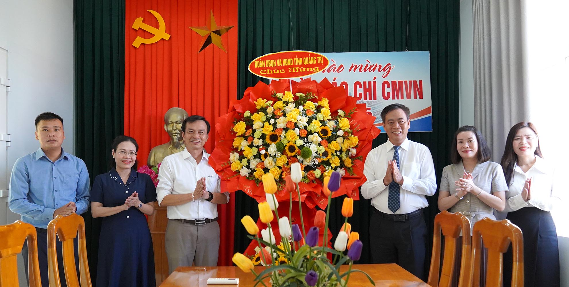 Đồng chí Phó Bí thư Tỉnh ủy, Chủ tịch HĐND tỉnh Nguyễn Đăng Quang tặng hoa, chúc mừng phóng viên Văn phòng đại diện Báo Nhân dân tại Quảng Trị- Ảnh: C.H
