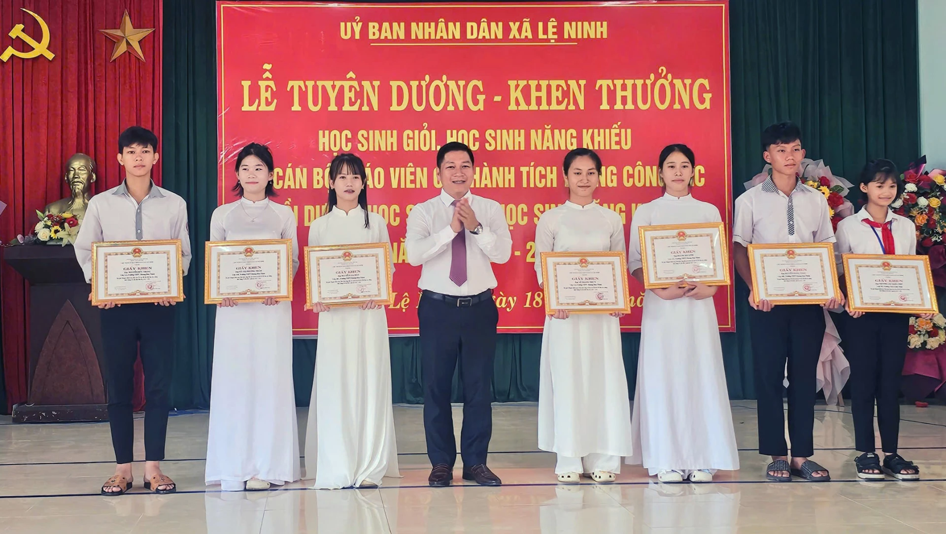 Đại diện lãnh đạo xã Lệ Ninh tặng giấy khen cho các học sinh đạt thành tích cao trong năm học 2025-2026-Ảnh: L.Chi
