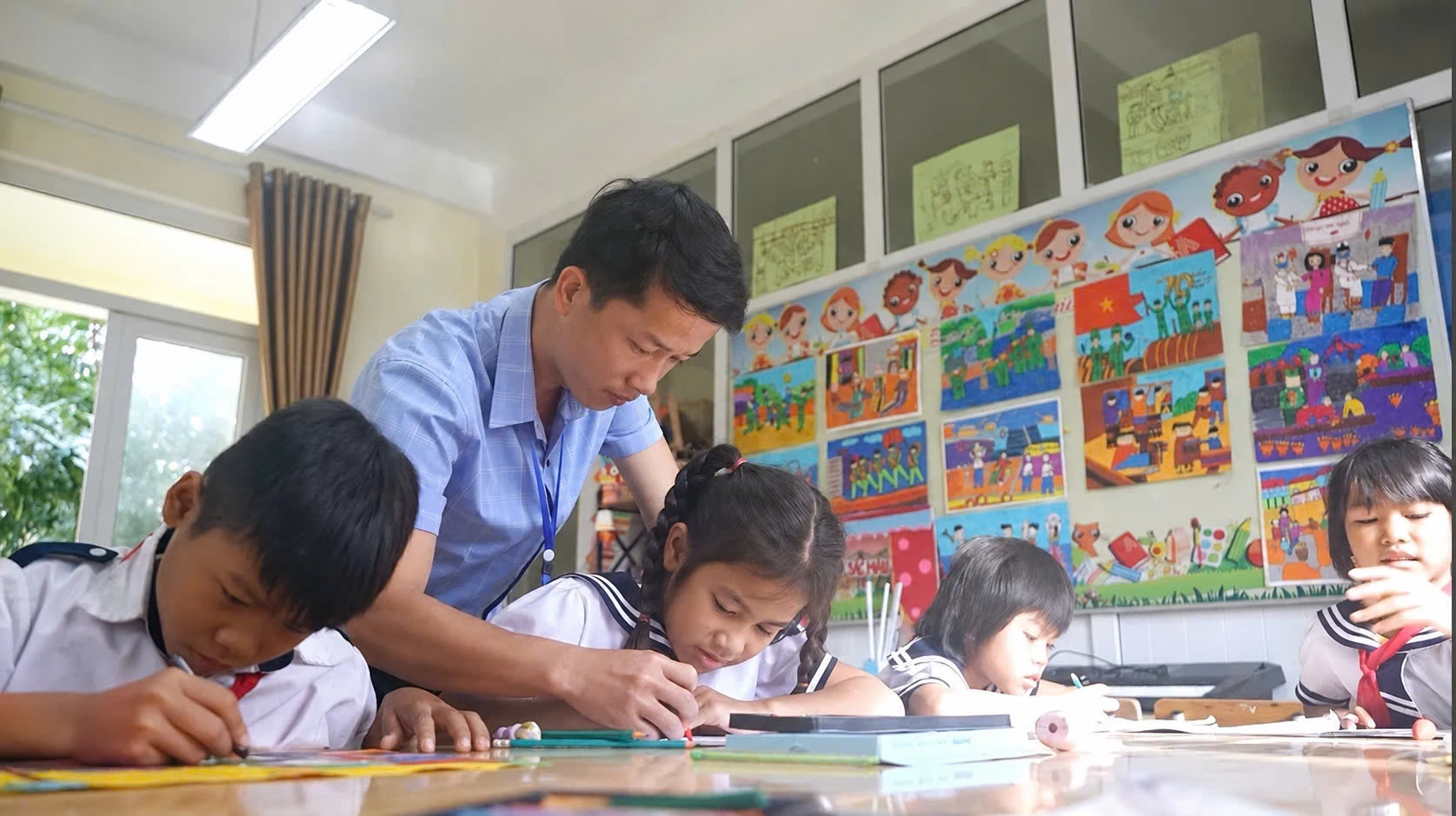 Họa sĩ Lê Quang Sáng với các học trò tại Trường tiểu học Tà Long- Ảnh: A.T
