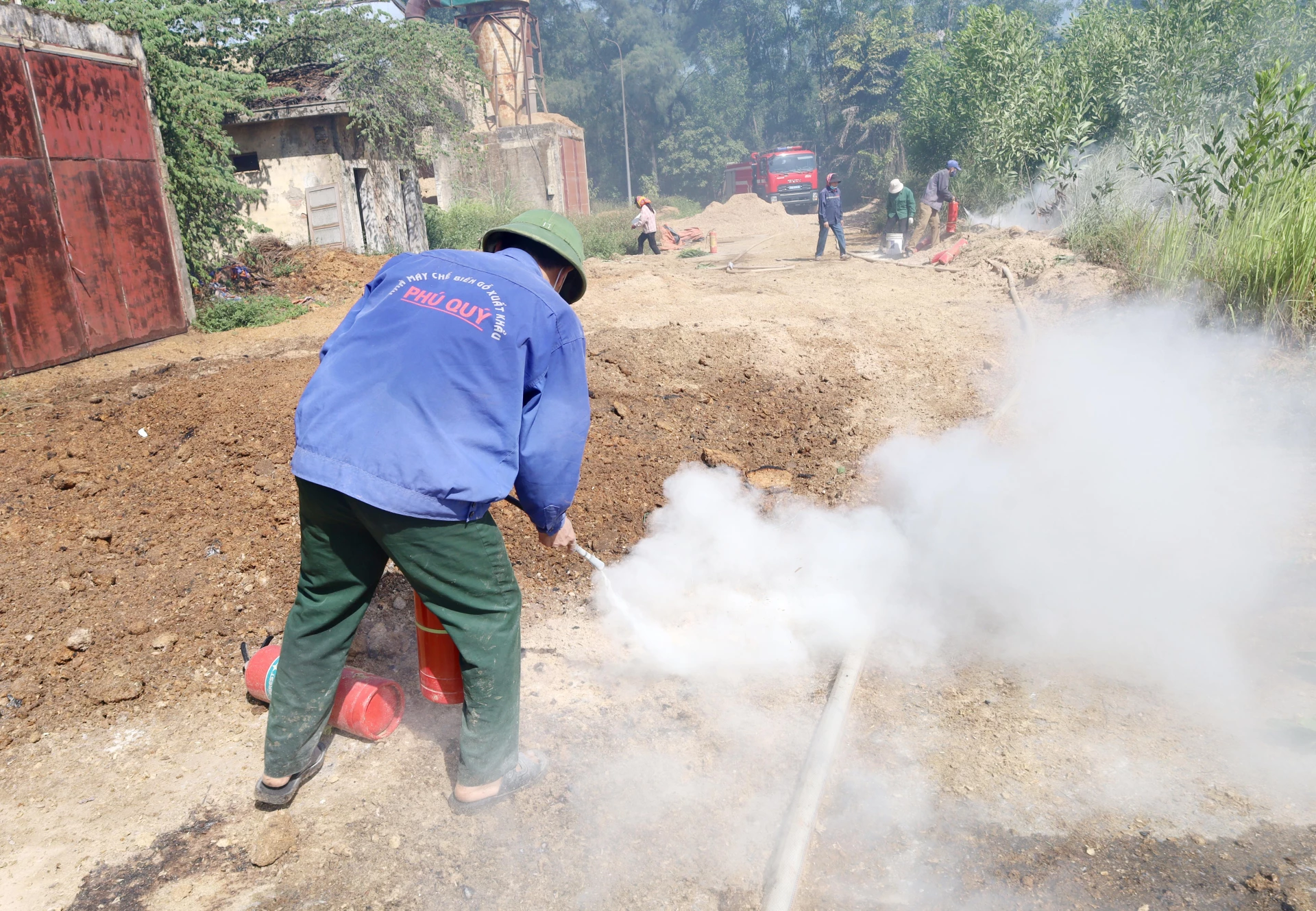 Nhiều bình chữa cháy được công nhân Xí nghiệp Chế biến gỗ xuất khẩu Phú Quý huy động để tham gia chữa cháy - Ảnh V.Minh