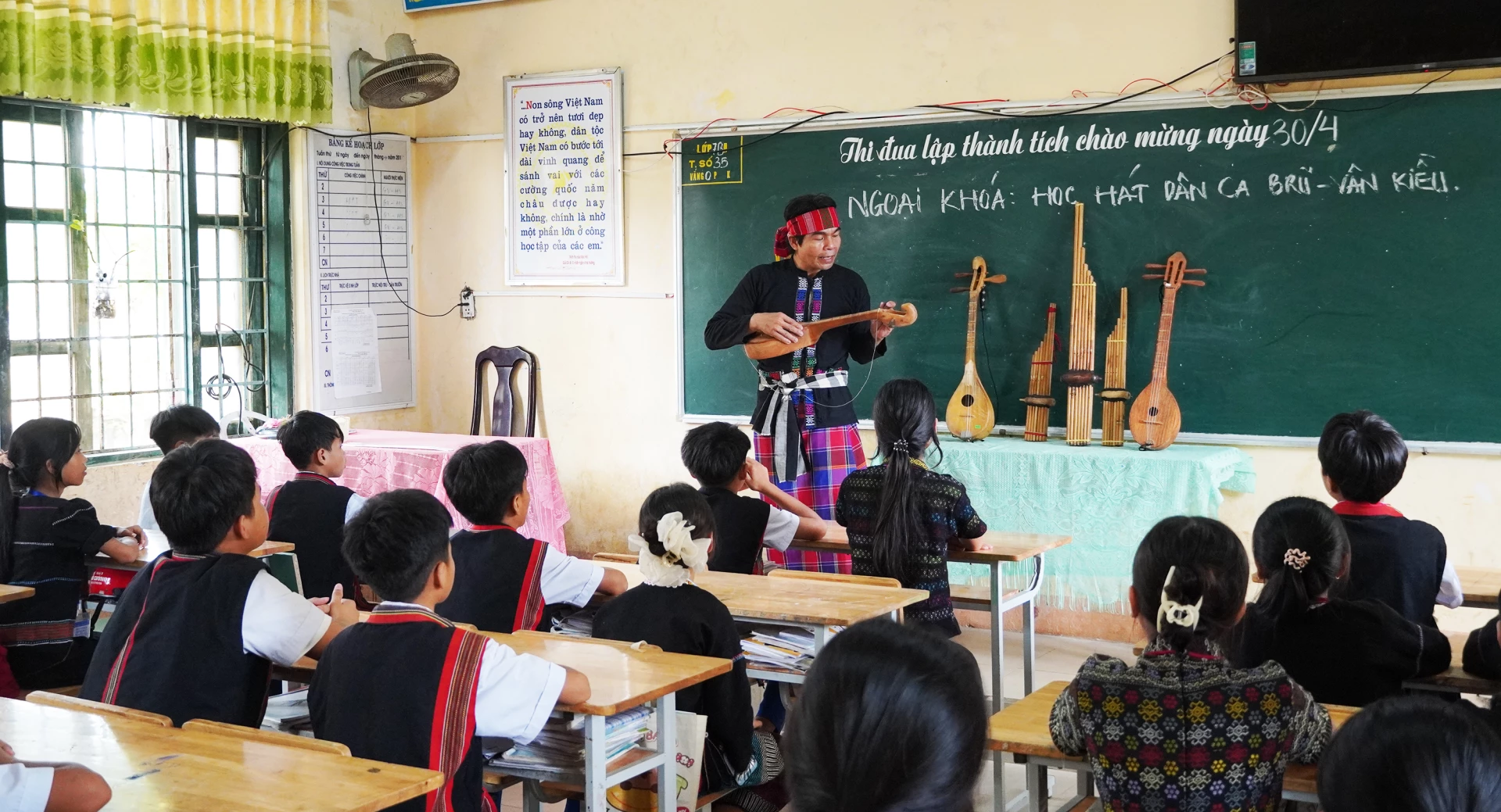 Nghệ nhân Hồ Văn Hồi truyền dạy dân ca và nhạc cụ dân tộc Bru-Vân Kiều cho các em học sinh - Ảnh: P.P