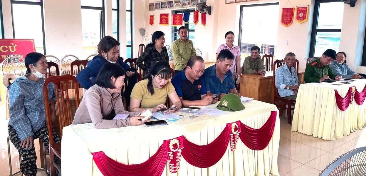 Tổ công nghệ số cộng đồng hướng dẫn cho người dân cài đặt các ứng dụng trên điện thoại - Ảnh: N.D