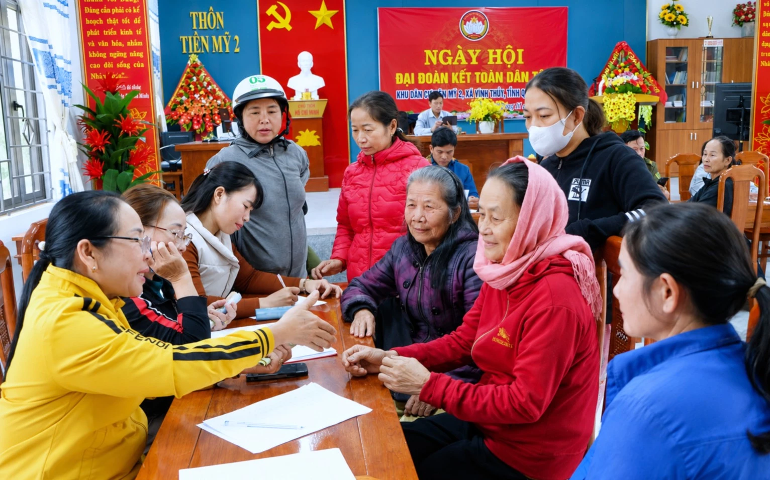 Bà Nguyễn Thị Xuân (áo vàng), Trưởng thôn Tiên Mỹ 2, tại buổi tiếp nhận hỗ trợ bà con ảnh hưởng lũ lụt tại miền Trung-Tây Nguyên - Ảnh: P.N