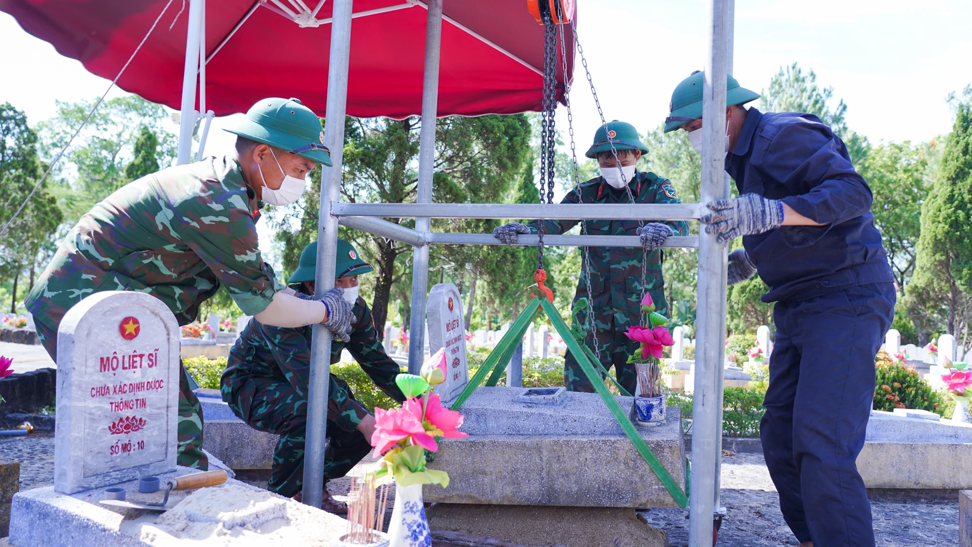 Để không thay đổi kết cấu các ngôi mộ, cán bộ, chiến sĩ Đội 584 đã tự chế ròng rọc nhằm giúp giảm sức người trong việc nâng hạ mộ - Ảnh: Lê Trường