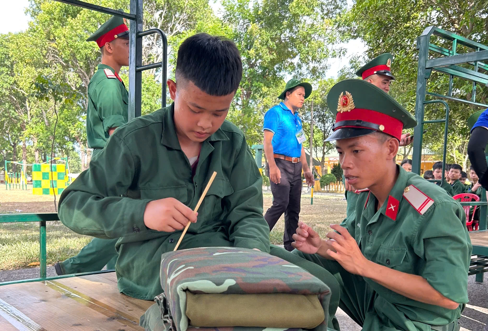 Các học viên được hướng dẫn kỹ năng gấp chăn gối gọn gàng - Ảnh: T.P