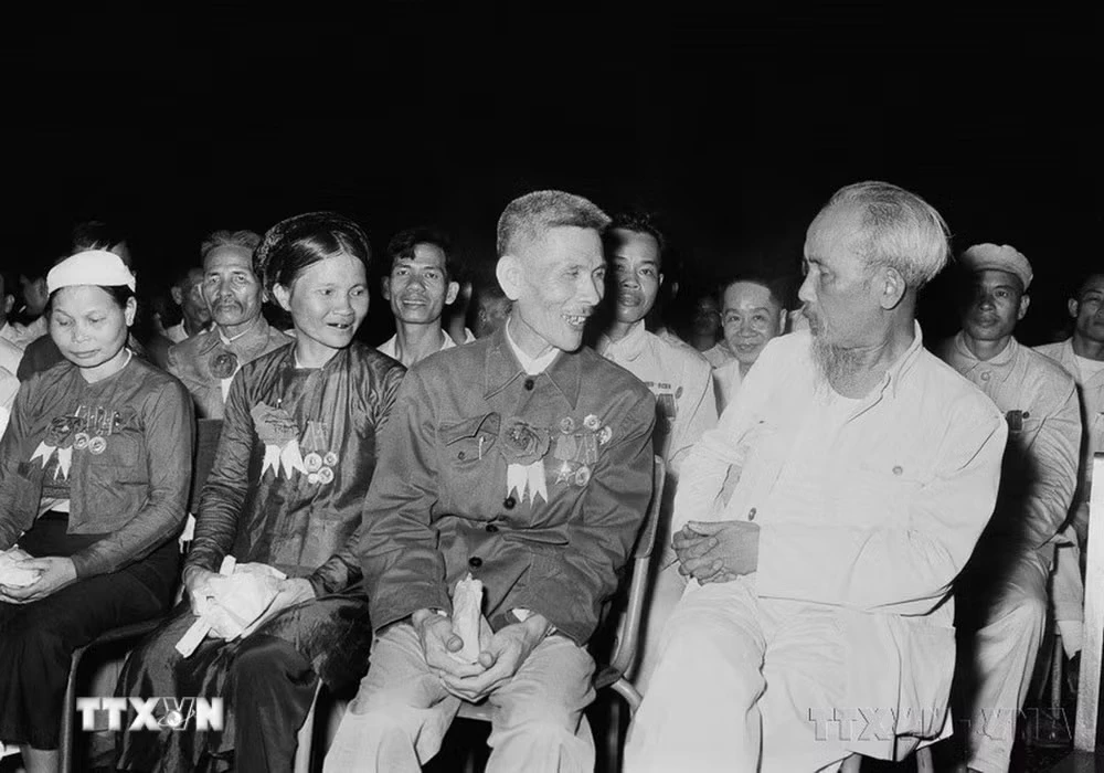Chủ tịch Hồ Chí Minh nói chuyện thân mật với Anh hùng Lao động Nguyễn Phúc Đồng (ngành Quân giới) và nữ Anh hùng Nguyễn Thị Năm (dệt Nam Định) trong buổi họp mặt các đại biểu dự Đại hội liên hoan Anh hùng, Chiến sỹ thi đua Công-Nông-Binh toàn quốc lần thứ II (Hà Nội, 7/7/1958). (Ảnh: TTXVN)
