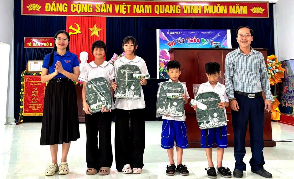 Đại diện lãnh đạo Đoàn phường Đồng Hới và nhà tài trợ trao quà cho các em học sinh - Ảnh: P.V.